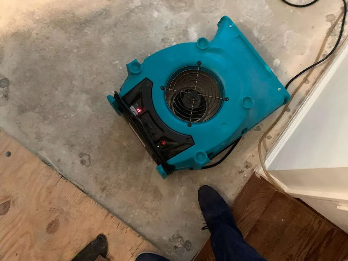 Air mover drying subfloor during Commercial Water Damage Restoration in Huron
